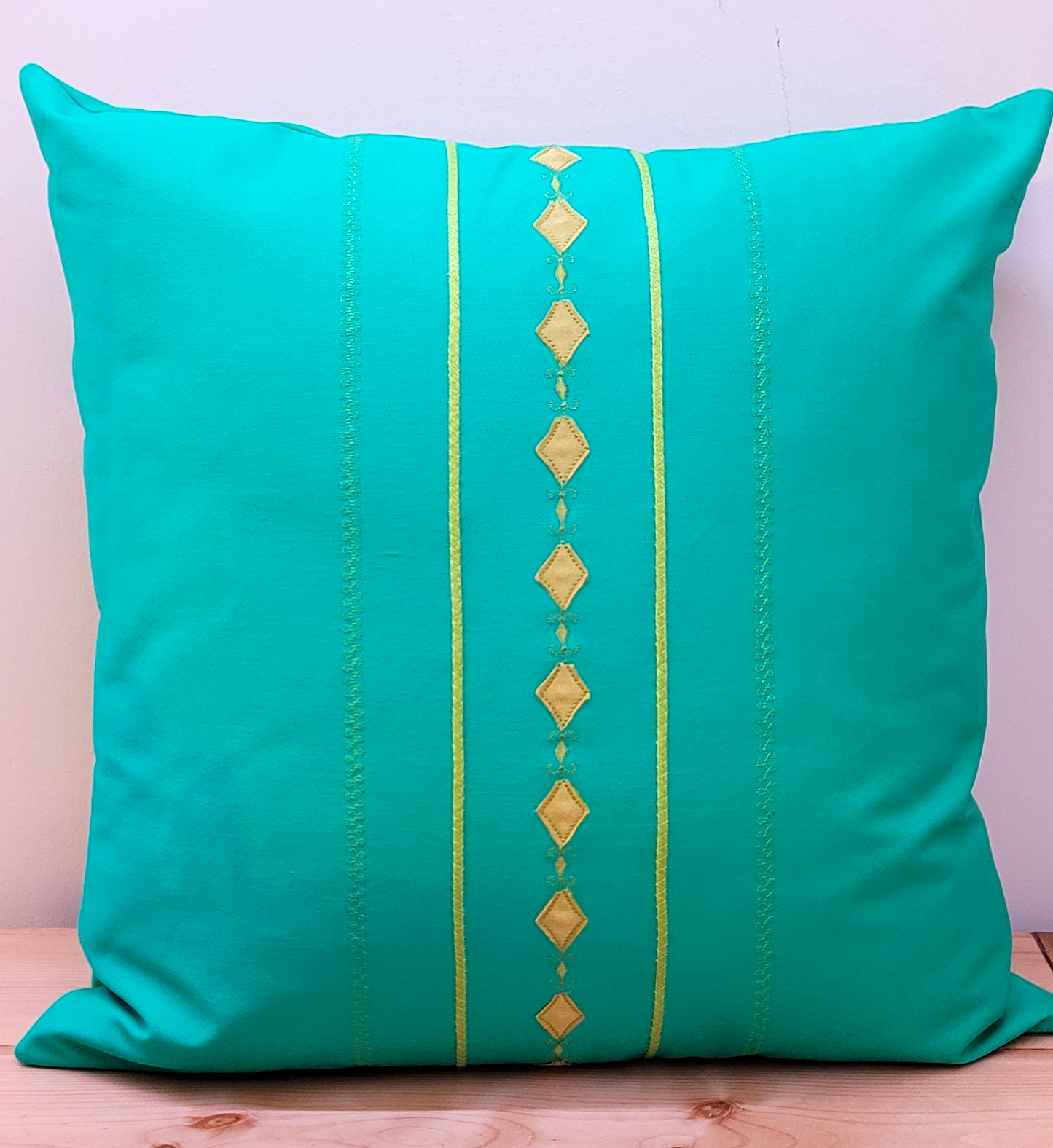 Green throw pillow cover with decorative trims.