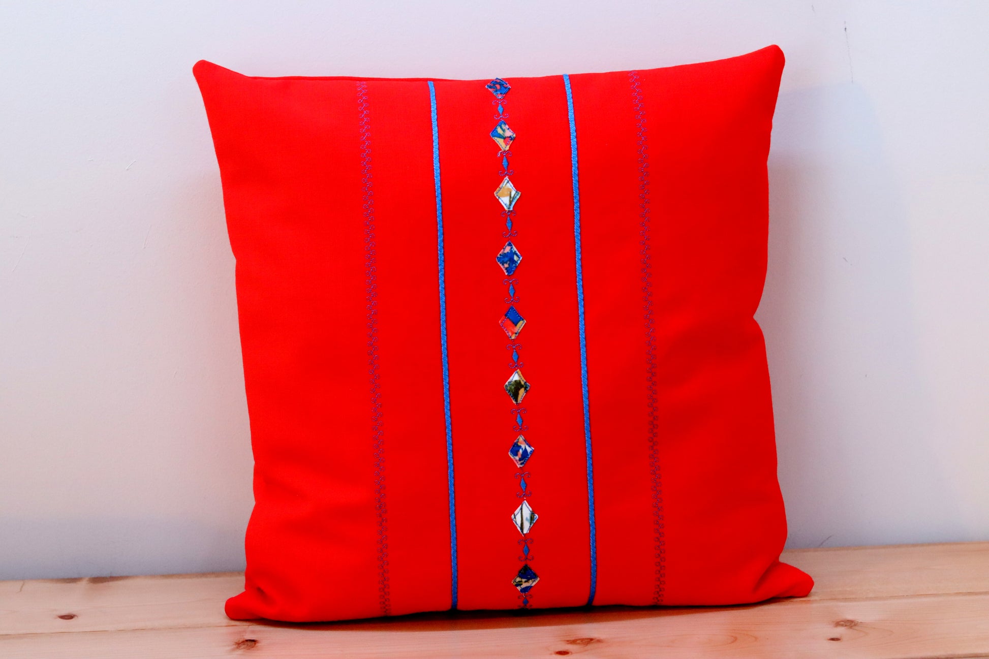 Orange square decorative throw pillow cover with decorative trims.