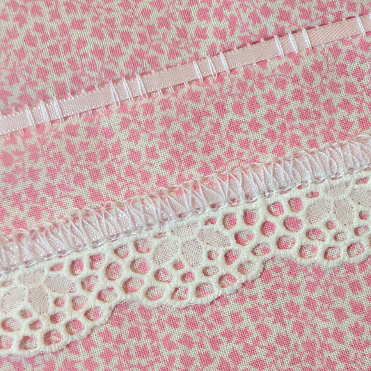 Detail of flatlock serger stitch with tatting trim and ribbon