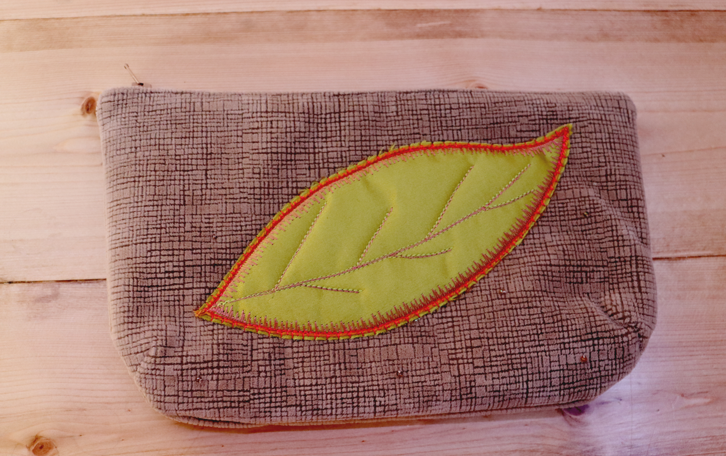 Blush pink clutch handbag with green leaf in appliqué