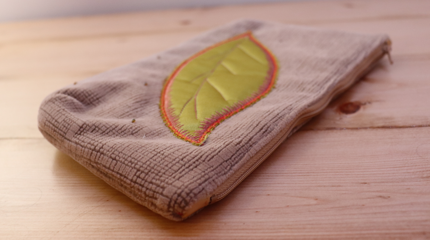 Details of blush pink and green leaf appliqué handbag clutch