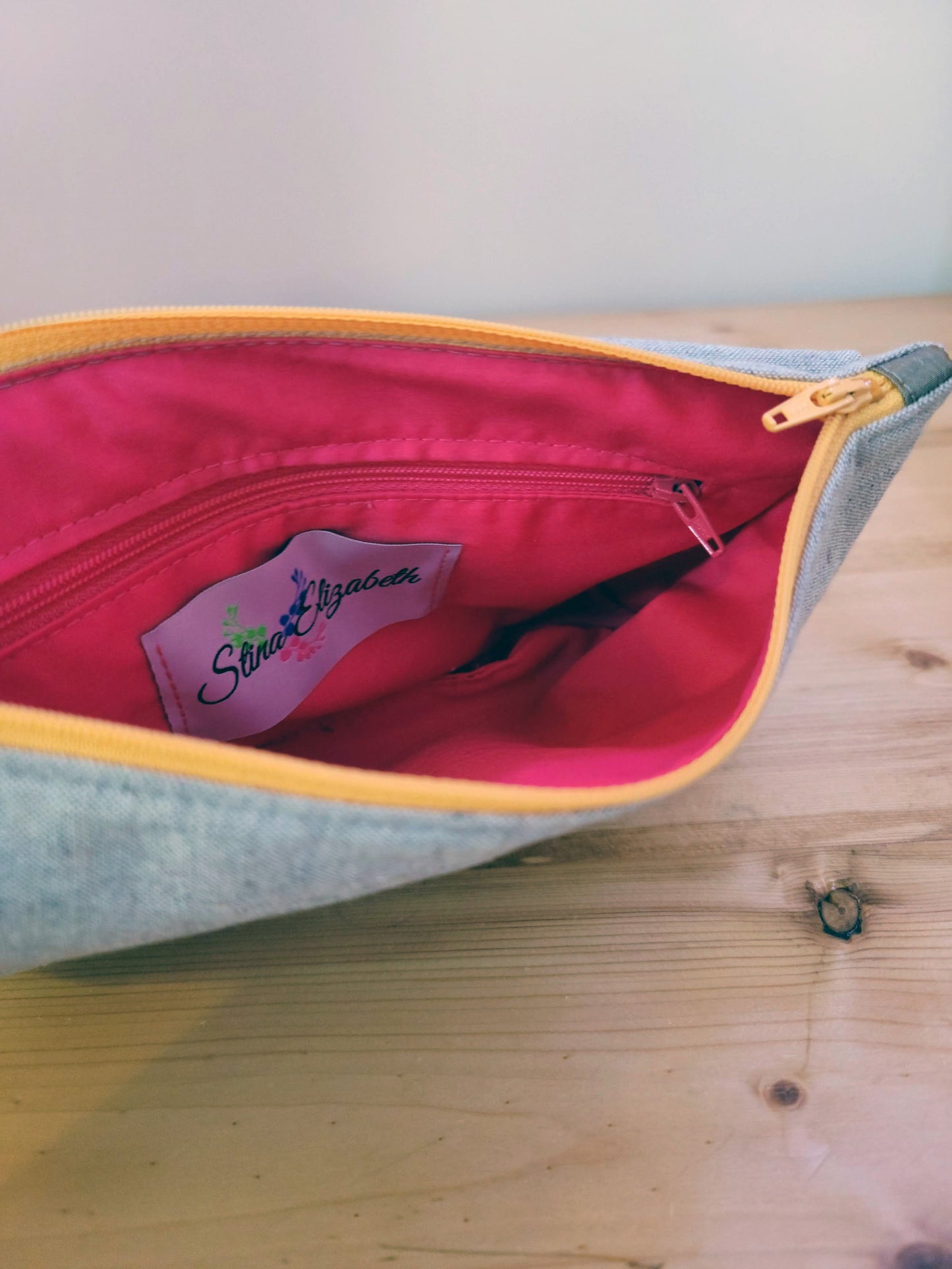 Inside view of gray handbag clutch and inside zippered pocket