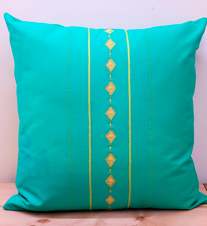 Green throw pillow cover with decorative trims.