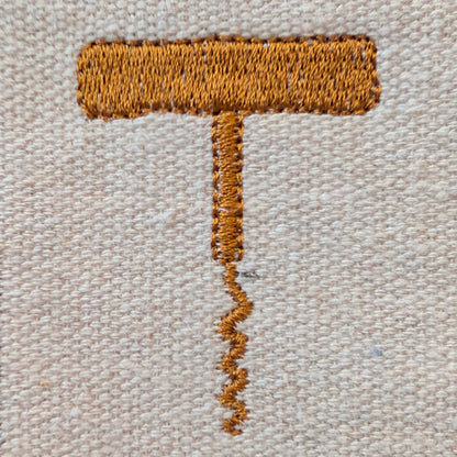 Embroidered corkscrew on a textured beige fabric background