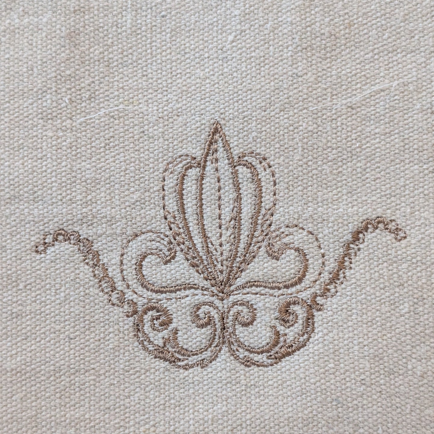 Decorative brown embroidery on beige fabric