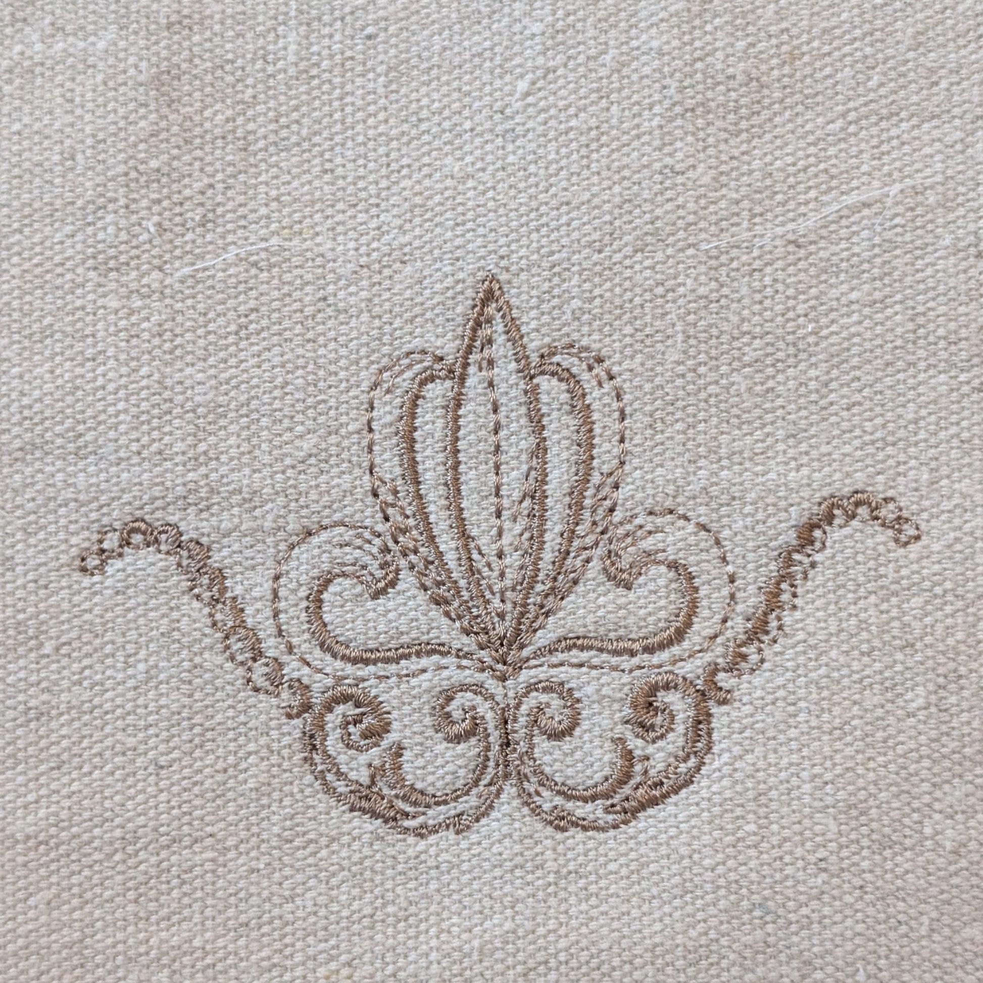 Decorative brown embroidery on beige fabric