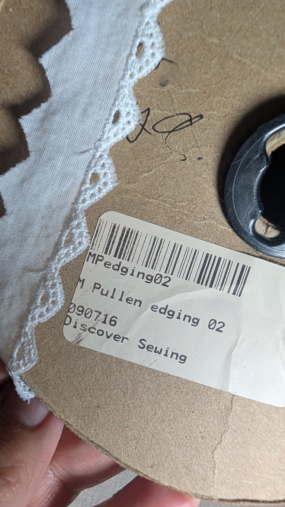 Close-up of triangular Swiss cotton edging Martha Pullen brand in white and product label 