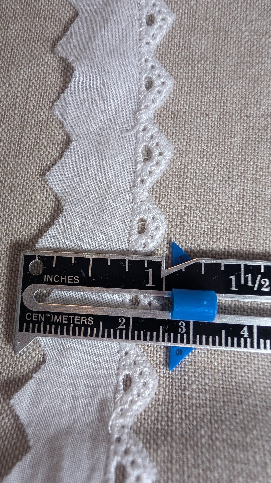 Close up of Swiss cotton edging trim with measuring gauge