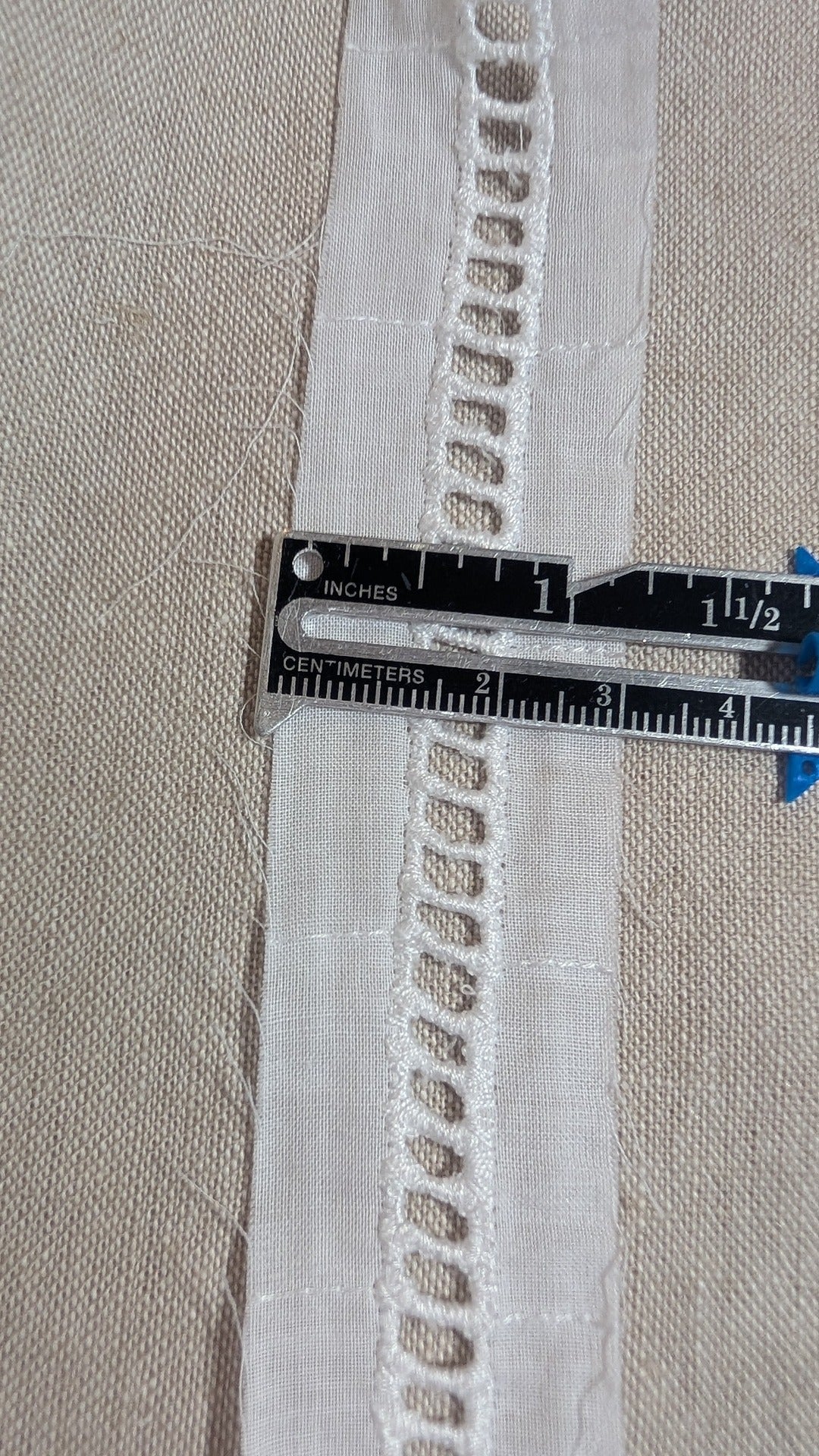 Close-up of ladder beading heirloom trim in white from Martha Pullen and measuring gauge.