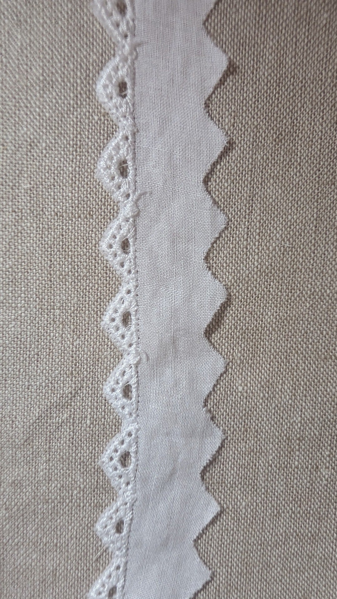 Close up of cotton Swiss edging trim in white, with small triangular form