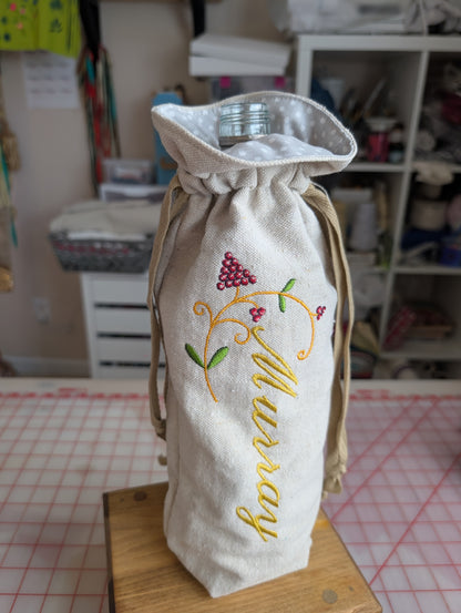 Embroidered fabric bag with 'Murray' text on a table in a workshop setting
