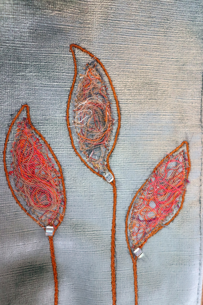 Details of appliqué leaves in gray and orange of grayish and blue handbag clutch
