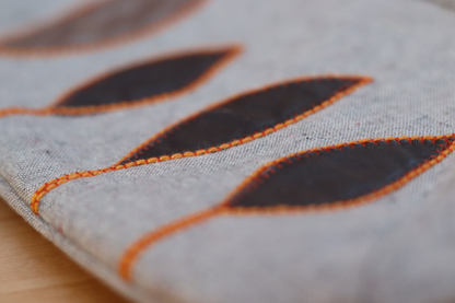 Detail also of appliqué on gray flap handbag clutch